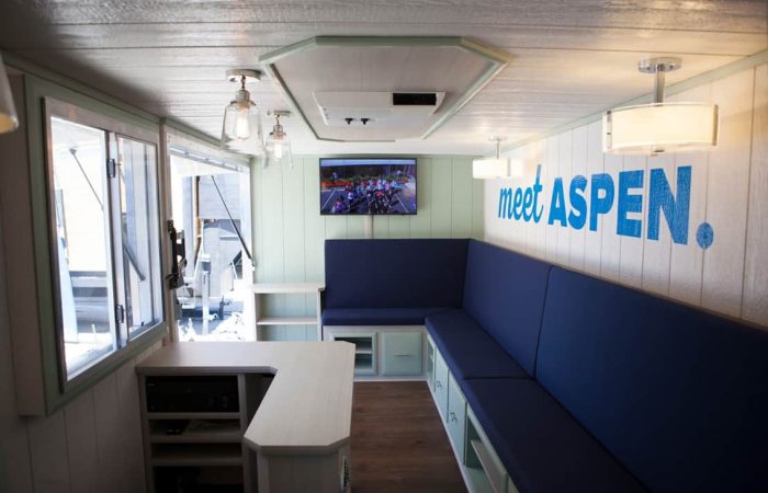 The Aspen Heights Mobile Office Truck is a perfect setup example for on-the-go professionals or businesses looking to grow their brand with functional assets. This mobile office truck is equipped with custom made bench seating, custom upholstery, light fixtures, fridge, custom-fabricated L-shaped low counter, TVs, state of the art speaker system & exterior wrap designed by Just Print It and applied by the team at Cruising Kitchens utilizes any mobile office truck to also serve as a moving billboard.