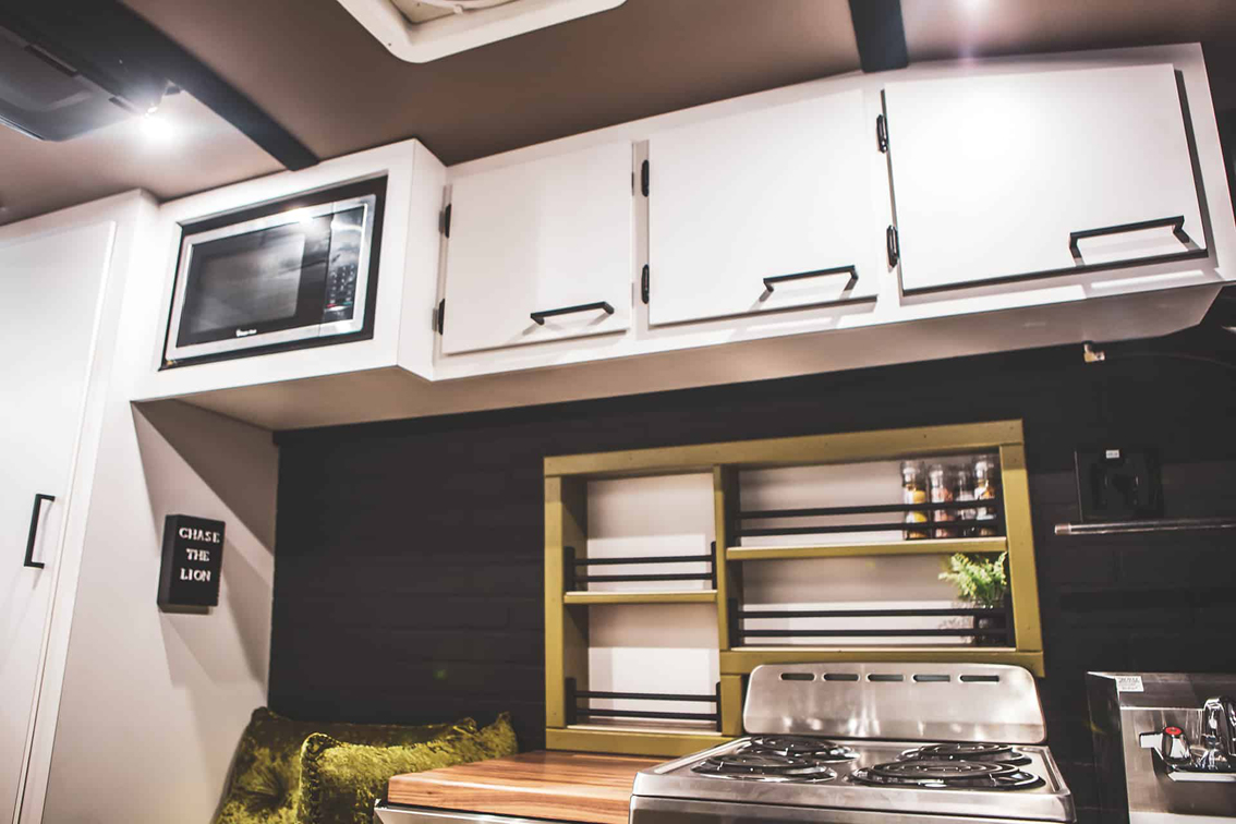 Custom built vans from Cruising Kitchens are the perfect way to "Live Life on Purpose." This Avril LaVan Off The Grid Overlander Van is complete with a custom grill featuring several plasma cut-out sasquatches, and a livable space including bed and L shaped bench seating.