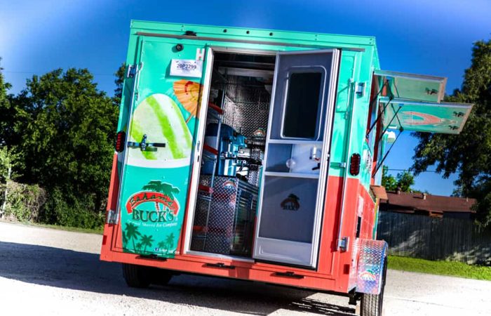 Bahama Bucks Shaved Ice Food Trailer is built by Cruising Kitchens to provide an exceptional experience for customers looking for a refreshing sno-cone. This sleek design features high-quality equipment and graphics to ensure that your business stands out from the competition.