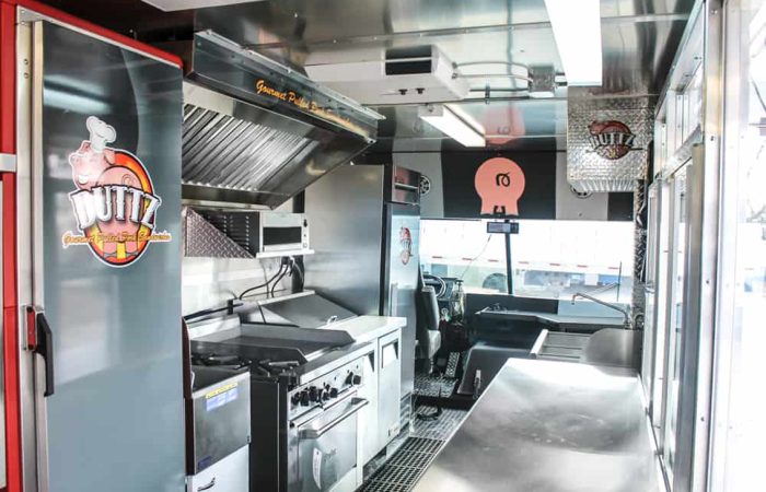 The Buttz BBQ food truck is a perfect example of how you can customize your food truck with Cruising Kitchens. This setup features a smoker, quick warmers, top of the line friers, and with their eye-catching winking pig logo, the wrap package is as memorable as it is sleek.