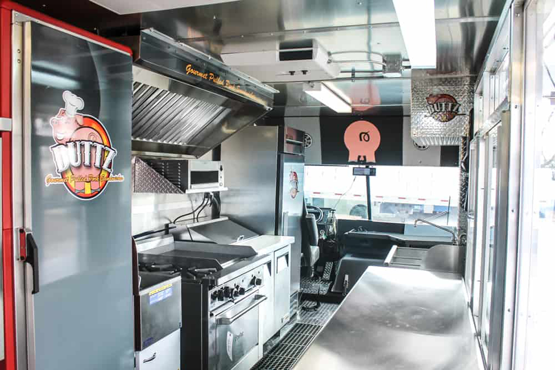 The Buttz BBQ food truck is a perfect example of how you can customize your food truck with Cruising Kitchens. This setup features a smoker, quick warmers, top of the line friers, and with their eye-catching winking pig logo, the wrap package is as memorable as it is sleek.