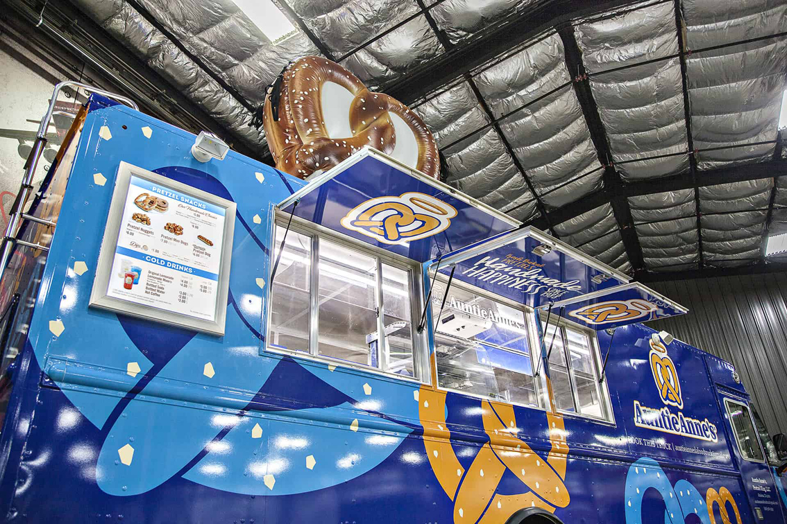 A top-tier build by Cruising Kitchens, this Auntie Anne's Food Truck is perfect for businesses looking to produce high quantities of quality soft pretzels. Equipped with state-of-the-art pretzel making equipment and a 4' long blow up pretzel, this truck can be customized to meet your specific needs.