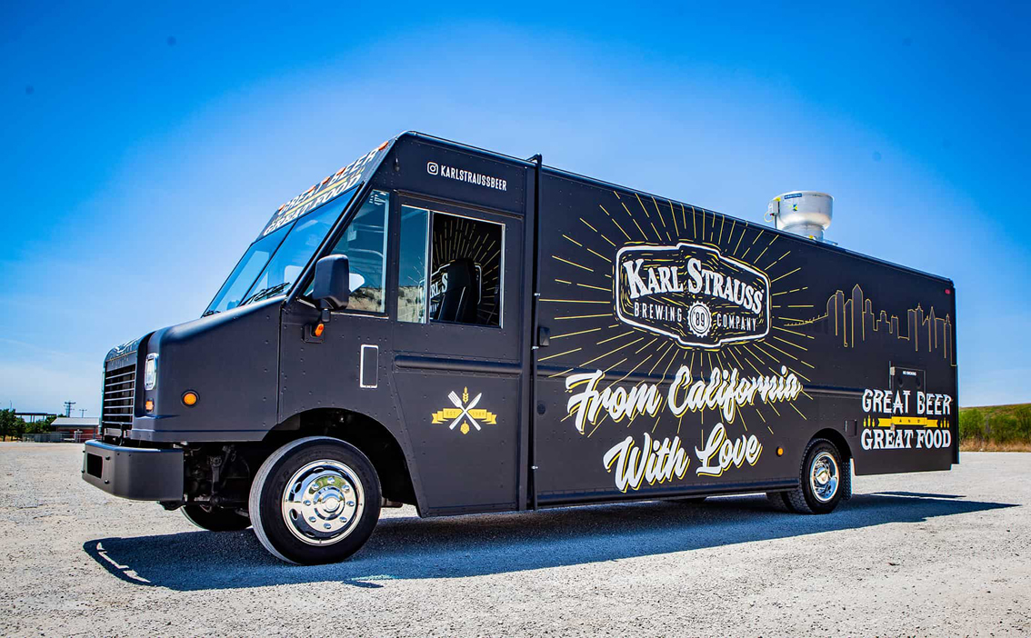 Karl Strauss Food Truck is the perfect way to experience the delicious food and craft beer that San Diego is known for. This top-of-the-line truck was built by Cruising Kitchens and features the Karl Strauss logo with beautiful views of the city in the background. Inside, you'll find top-of-the-line commercial appliances and 2 taps with cold refrigeration to serve ice cold craft beer.
