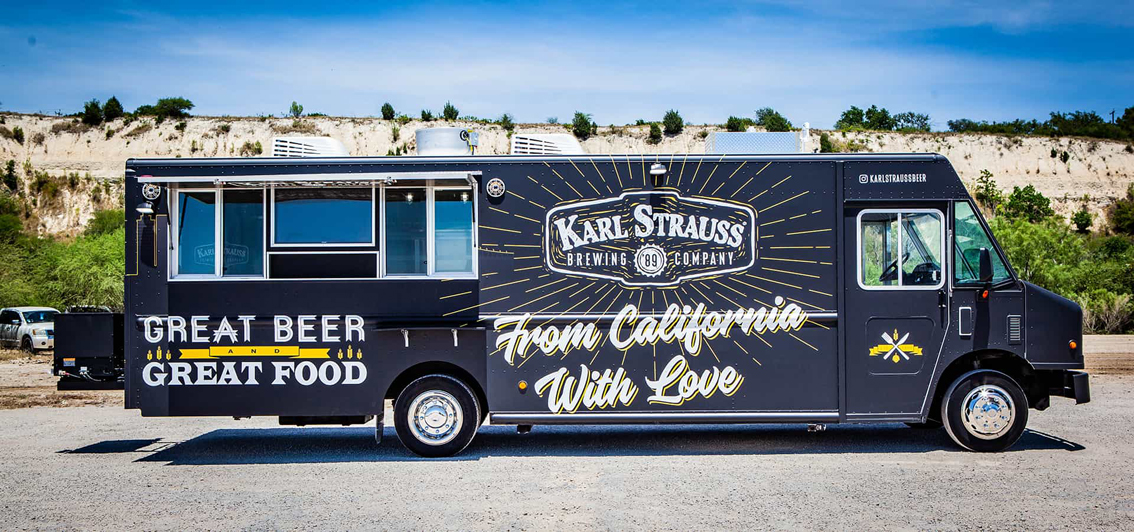 Karl Strauss Food Truck is a true innovation for San Diego's Karl Strauss Brewing Company. Built by Cruising Kitchens, this unique food truck features the Karl Strauss logo with contrasting colors and the beautiful San Diego skyline as backdrops. The top-of-the-line commercial appliances provide a quality culinary experience, while the 2 keg taps with ice cold refrigeration for the kegs. Including quality equipment to serve top of the line bar cuisine.